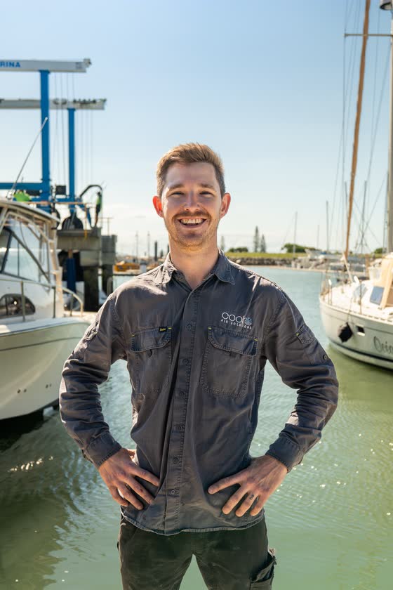Smiling tradesman standing at a marina